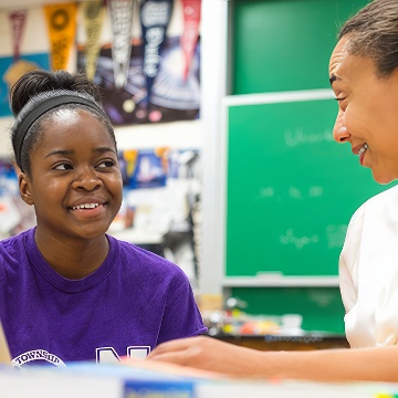 A student in a purple Tshirt listens to a teacher