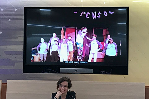 Erica Halverson in front of a screen showing students