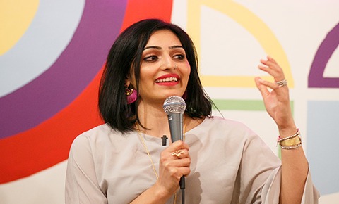 Foram Sheth holding a microphone speaking to audience