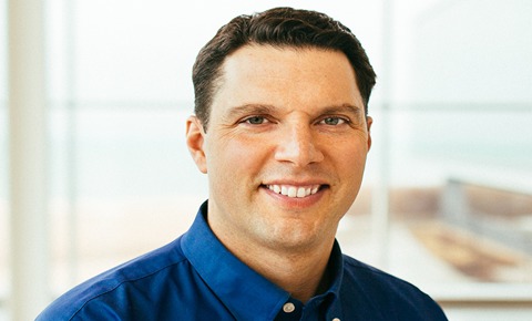Ryan Smerek similing at the camera in a blue shirt