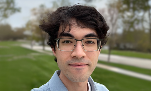 An image of Jason Kalafatis smiling for the camera in front of a grassy lawn.