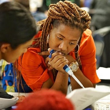 Women looking carefully at a book with a pen in her hands