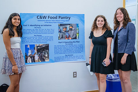 students in front of food pantry poster